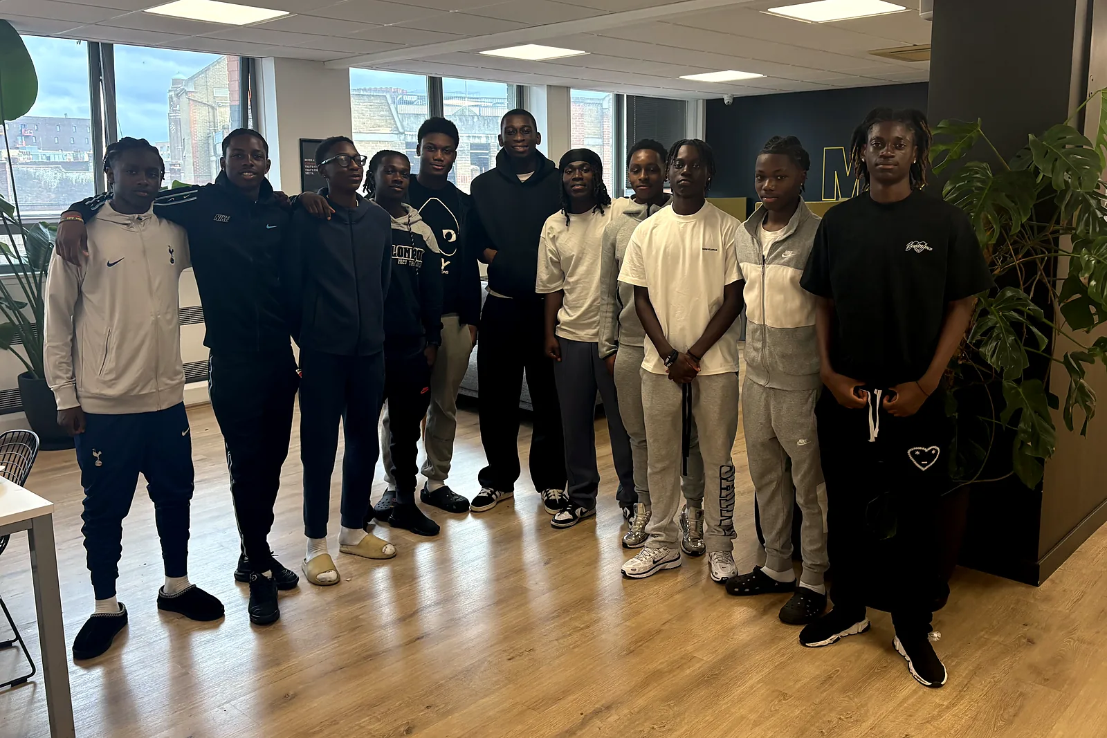 Twelve young people standing together at the end of a JDS session at Make It Barking